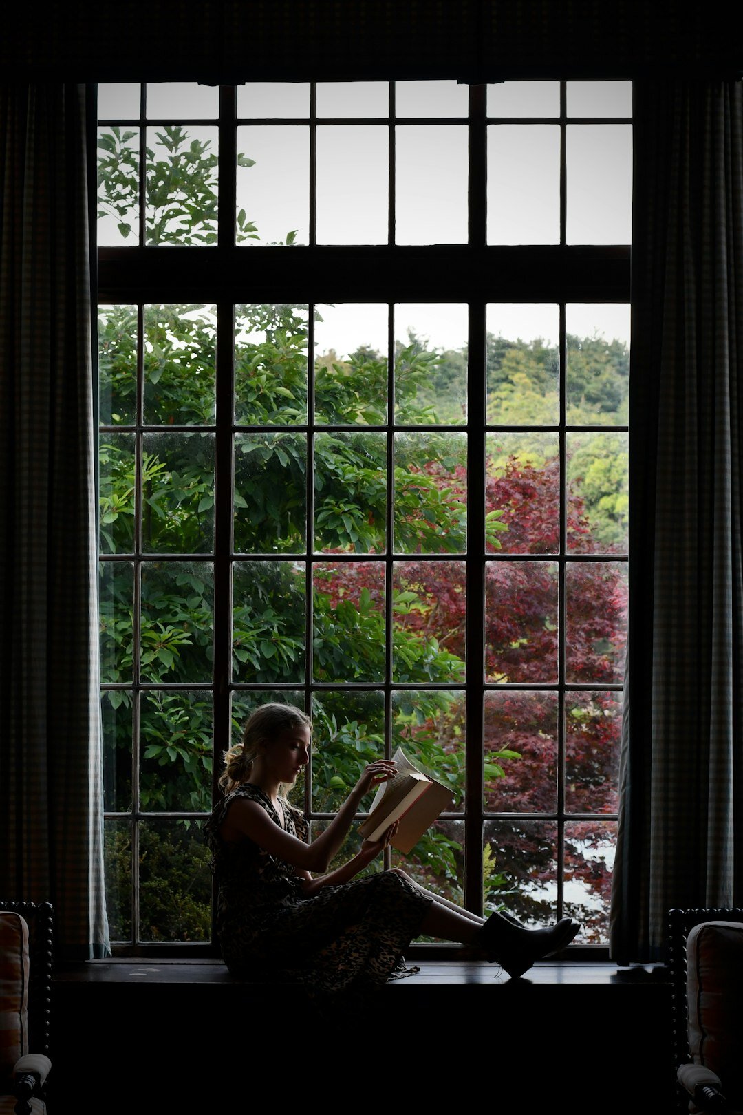 woman knitting by window